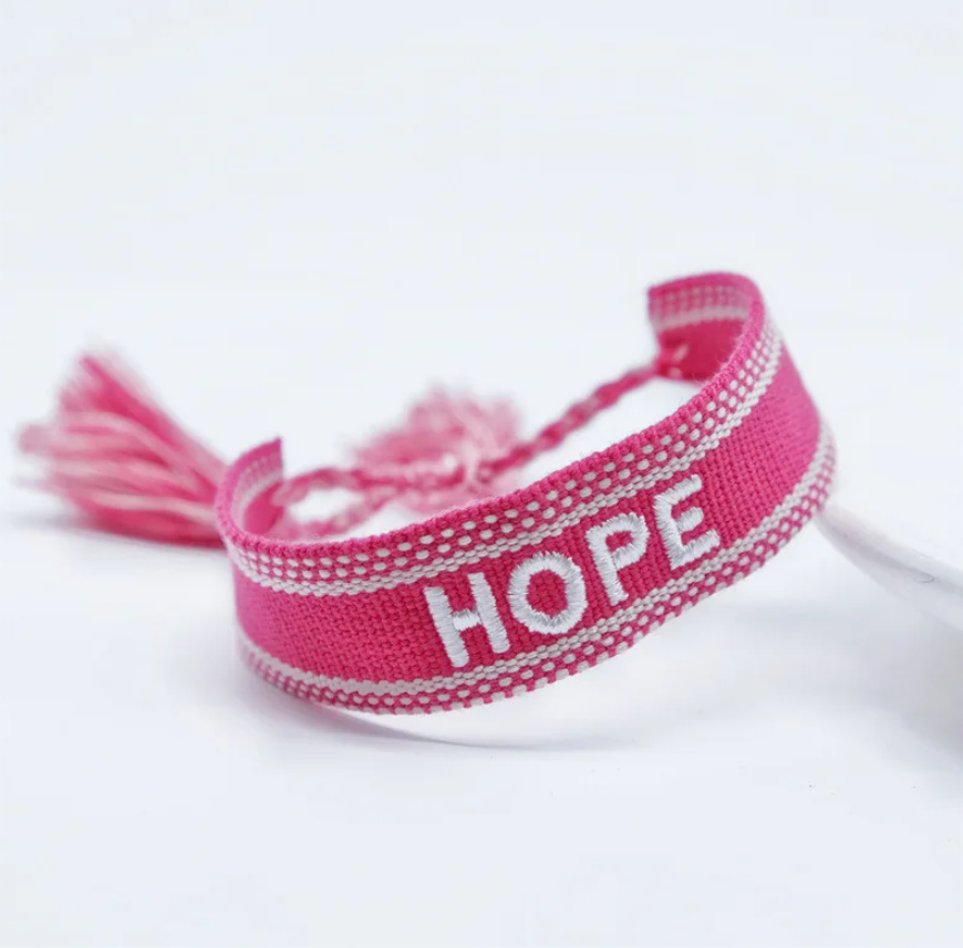 Bracciale in tessuto fuxia con scritta Hope ricamata bianca