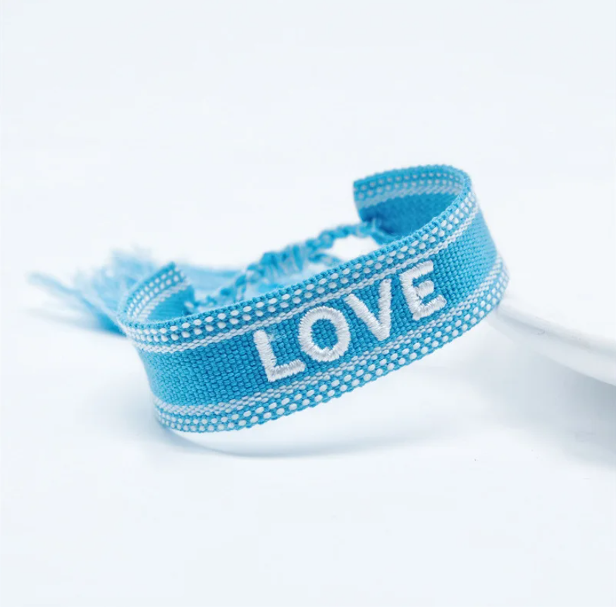 Bracciale in tessuto azzurro con scritta Love ricamata bianca