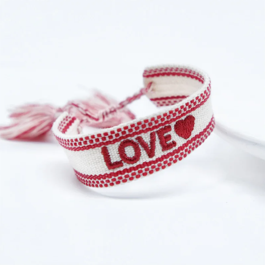 Bracciale in tessuto panna con scritta "love" ricamata rossa